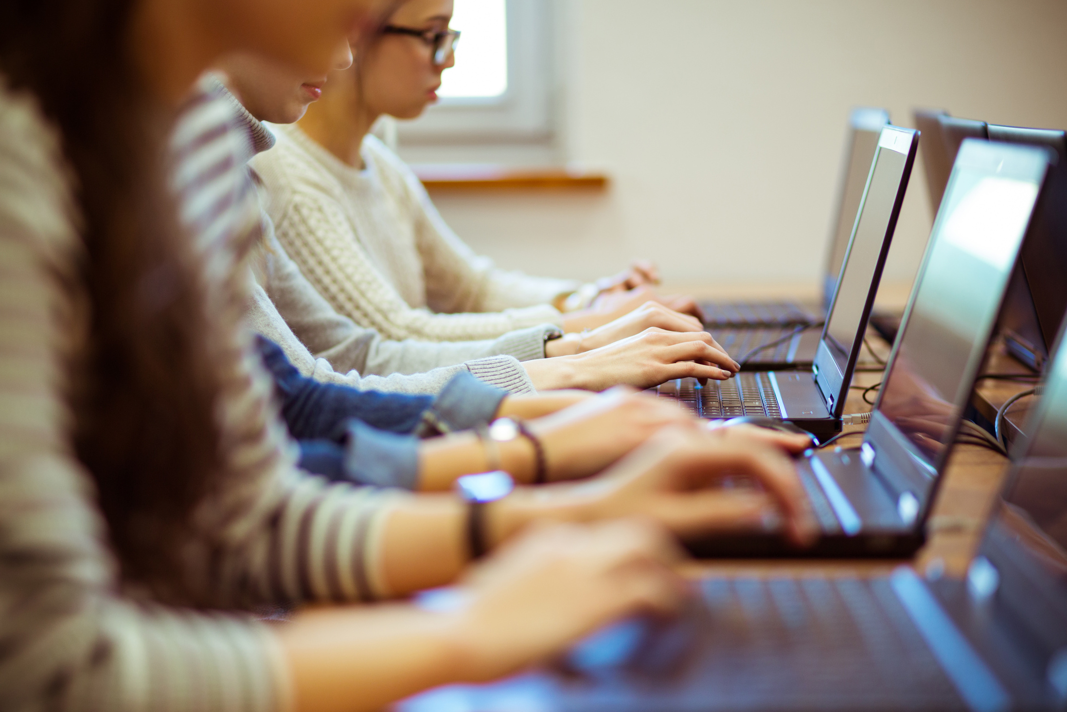 Female students learning computer programming on laptops
